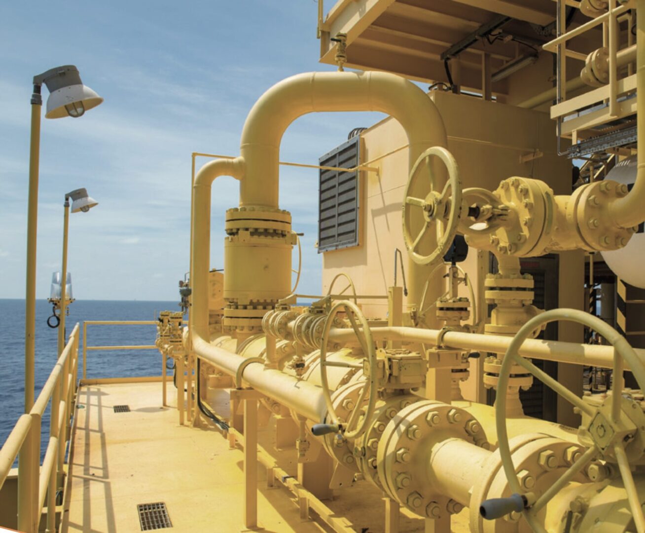 A large yellow pipe system on top of an oil rig.