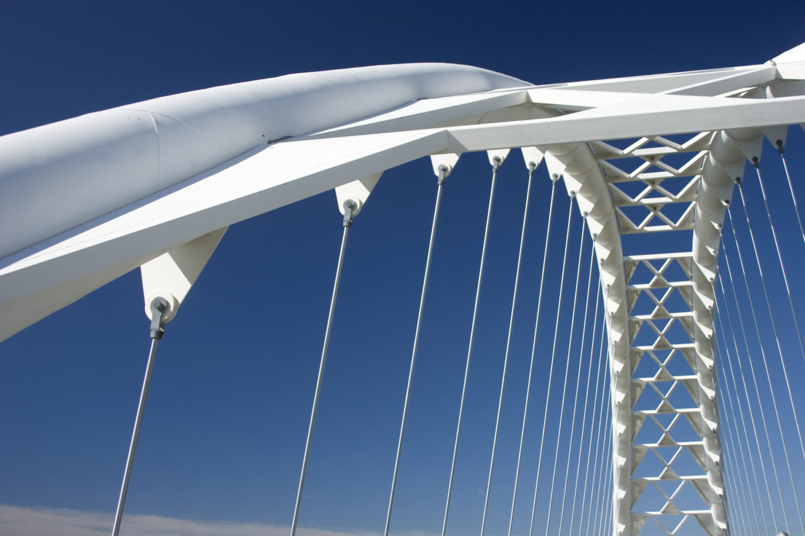 A white bridge with a blue sky in the background.